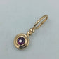 Goldfarbener Anhänger mit violettem Stein rund elegant