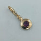 Goldfarbener Anhänger mit violettem Stein rund elegant