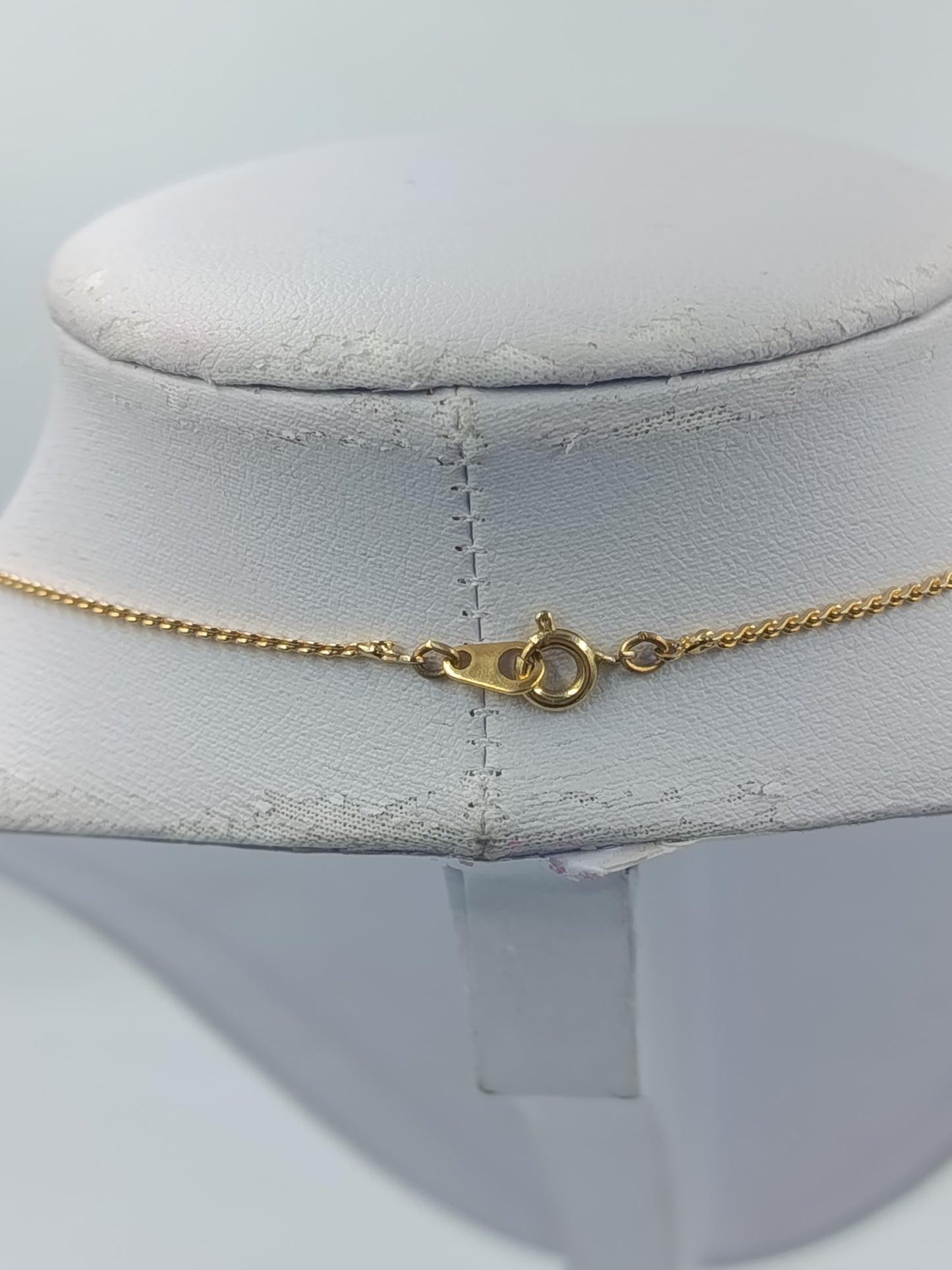 Goldfarbene Halskette mit schwarzen Steinen und Tropfenanhänger