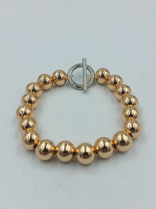 Goldfarbenes Kugelarmband mit silbernem Knebelverschluss