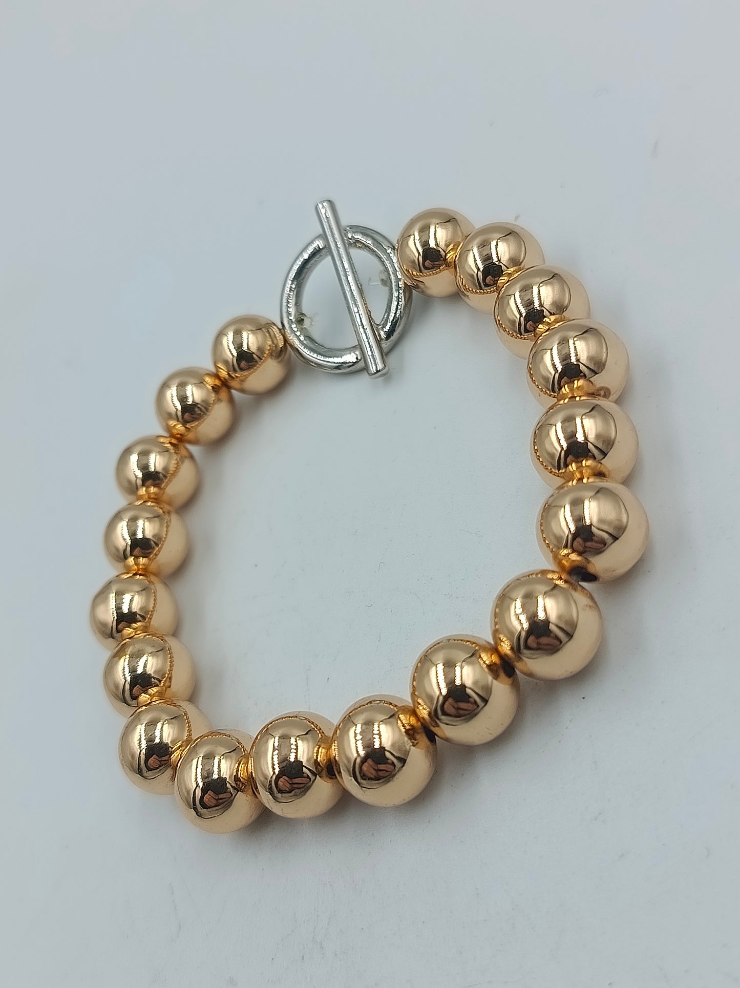 Goldfarbenes Kugelarmband mit silbernem Knebelverschluss
