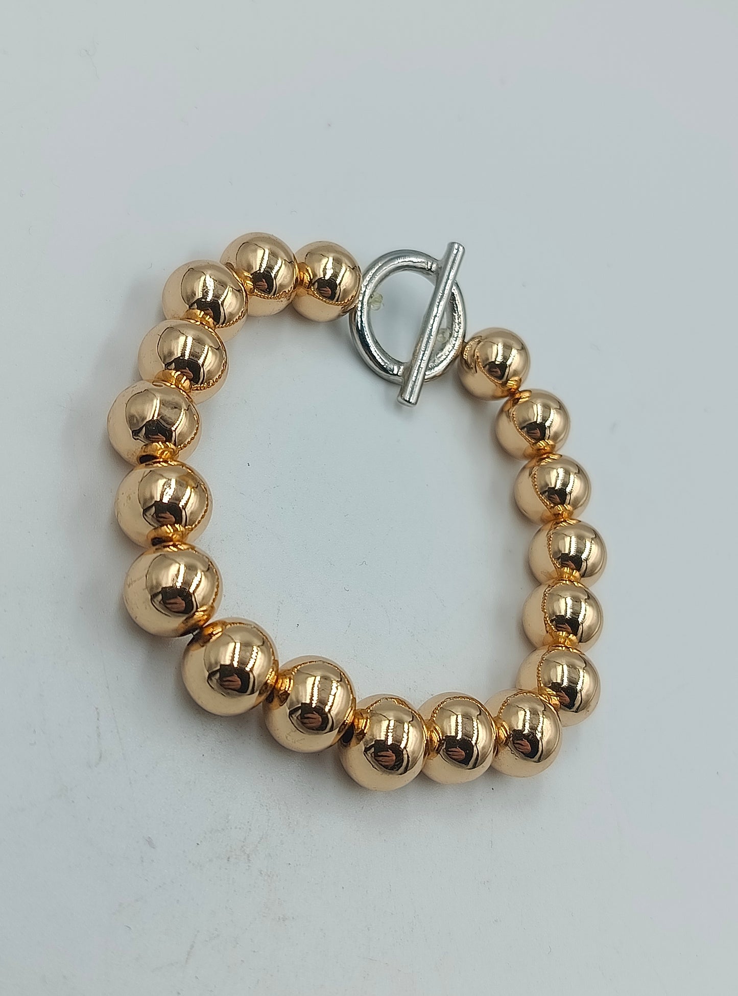 Goldfarbenes Kugelarmband mit silbernem Knebelverschluss