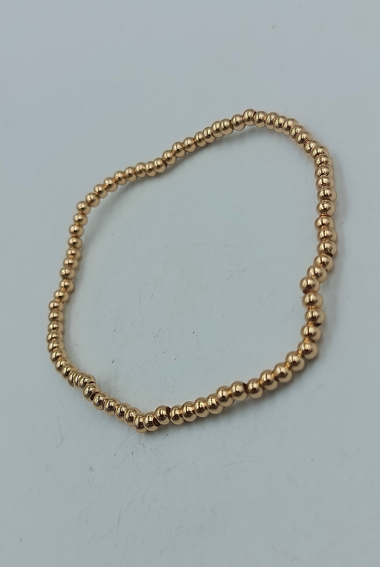 Feines elastisches Armband mit goldfarbenen Mini-Kugeln