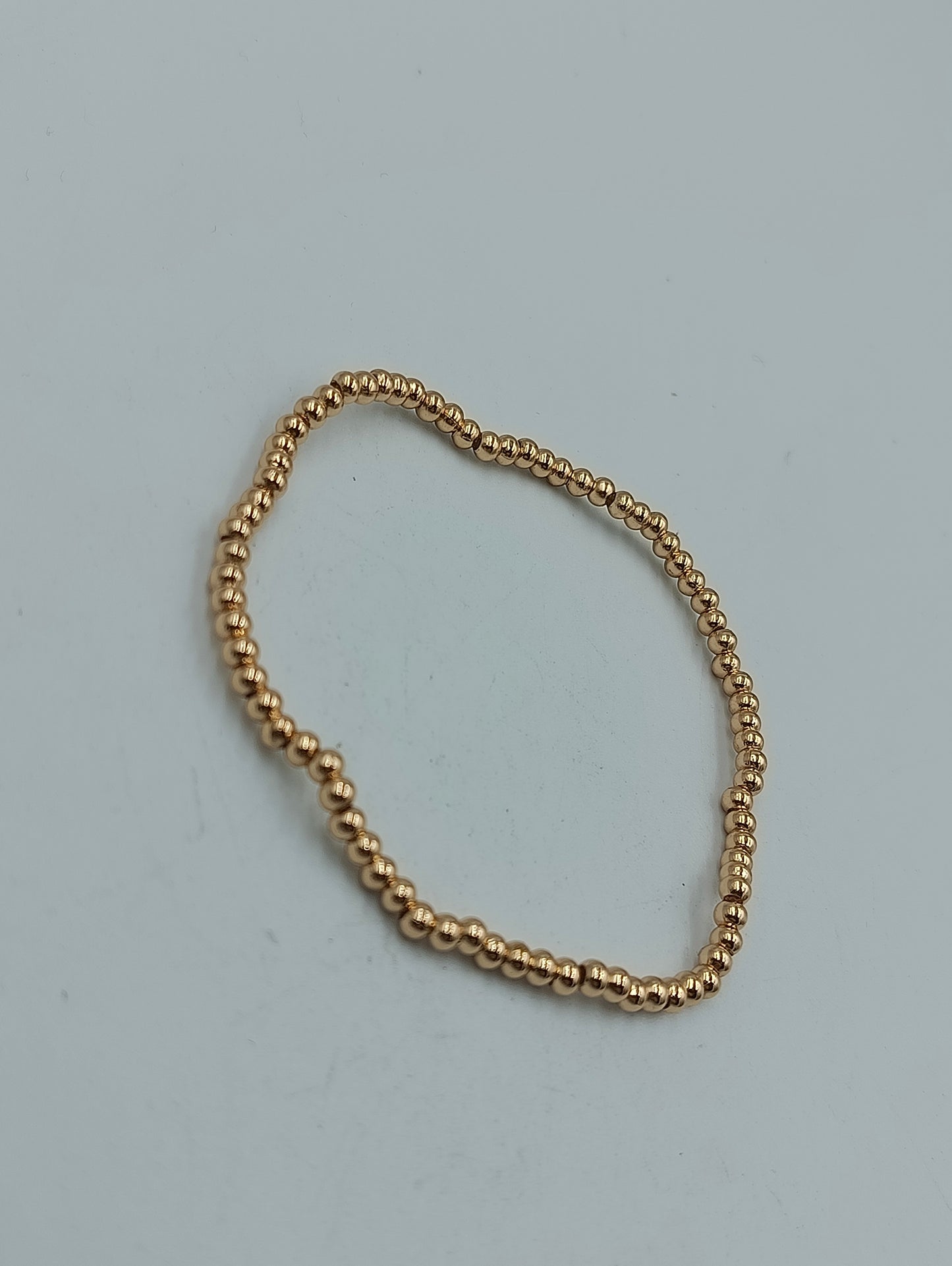 Feines elastisches Armband mit goldfarbenen Mini-Kugeln