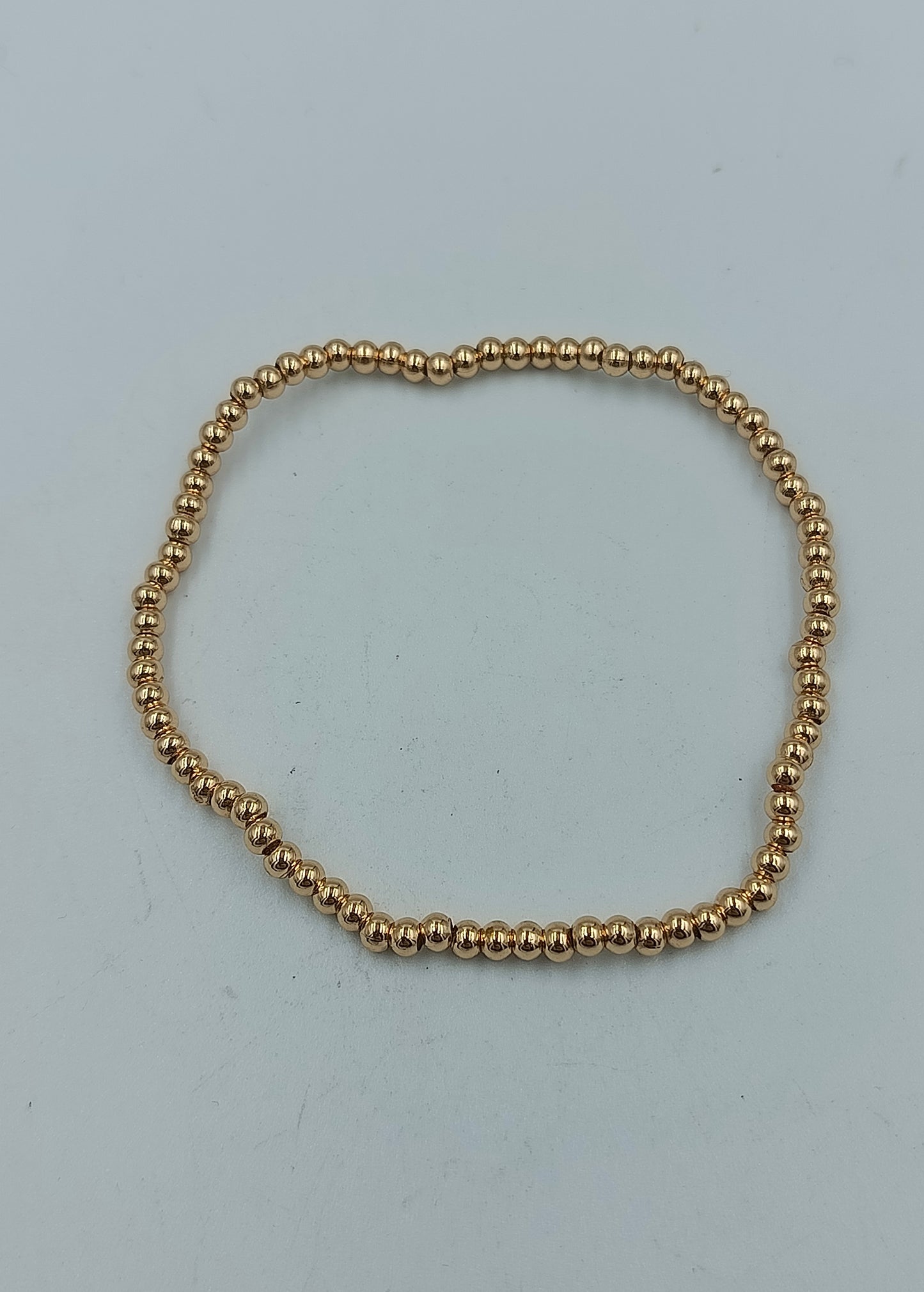 Feines elastisches Armband mit goldfarbenen Mini-Kugeln