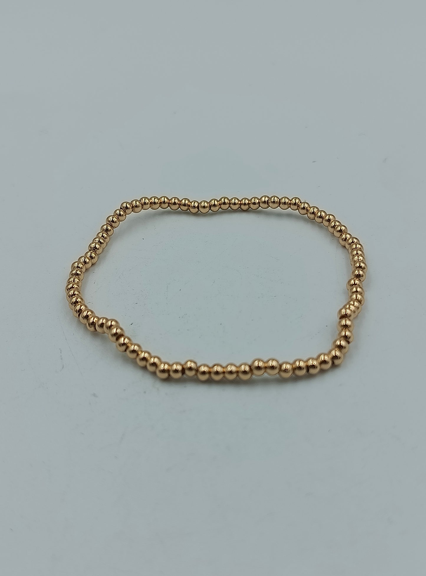 Feines elastisches Armband mit goldfarbenen Mini-Kugeln