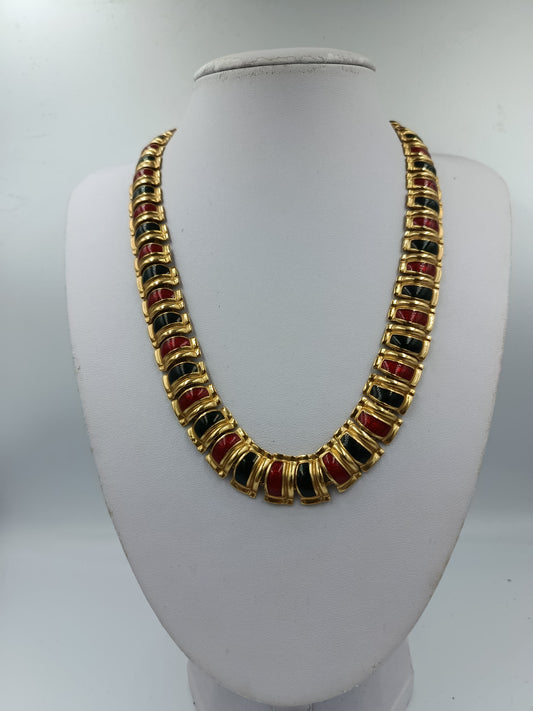 Halskette mit goldfarbenen Gliedern und rot schwarzen Emaille Elementen