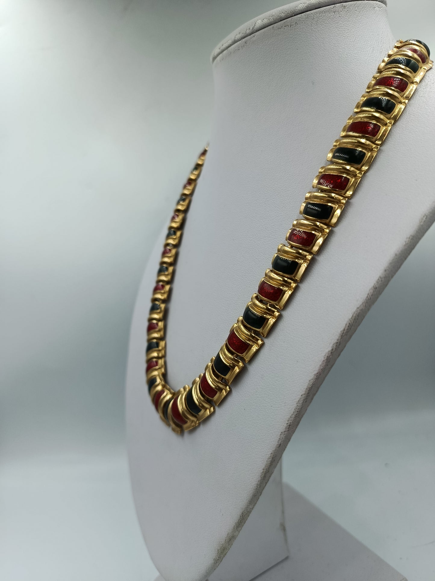 Halskette mit goldfarbenen Gliedern und rot schwarzen Emaille Elementen