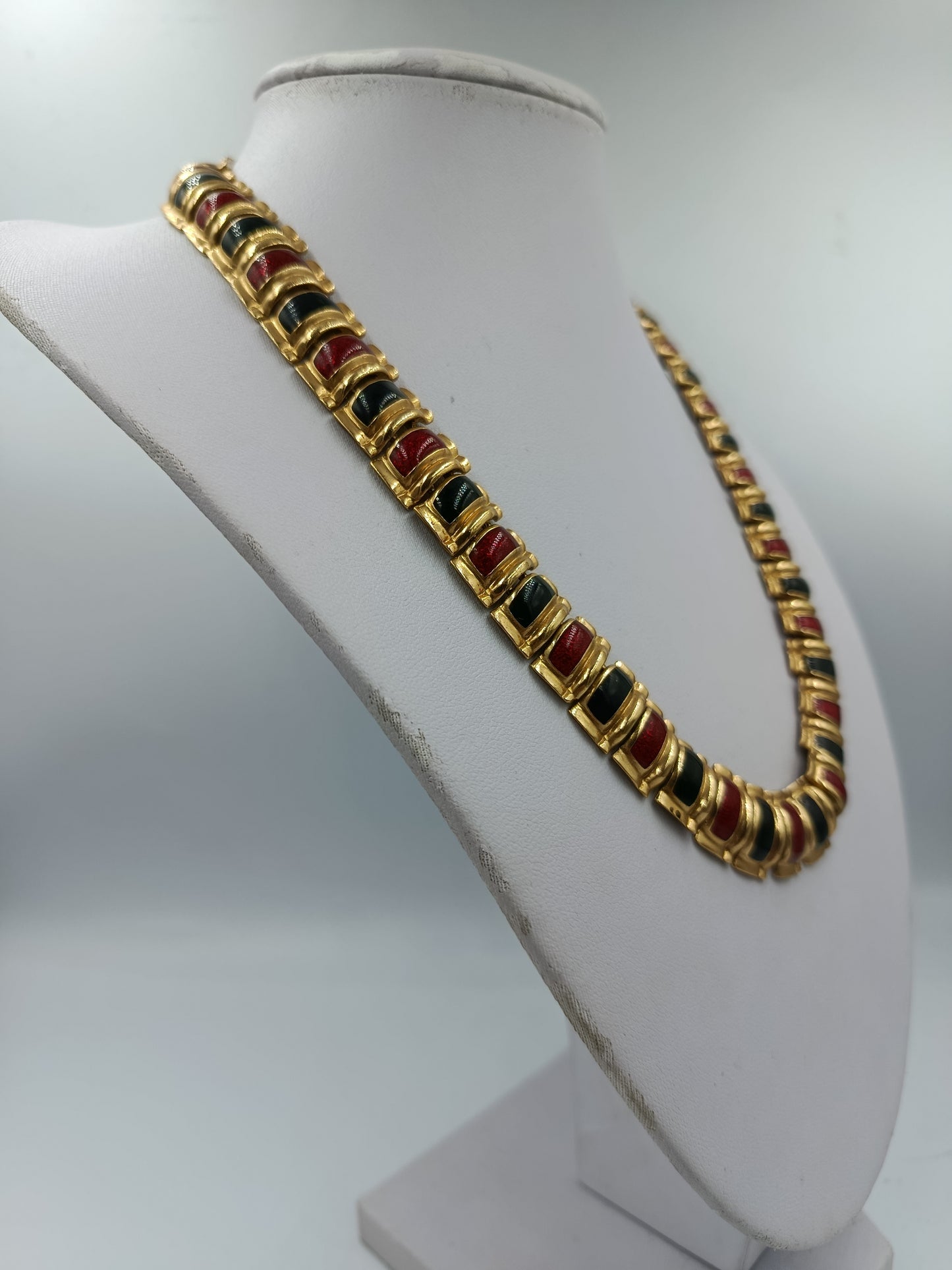 Halskette mit goldfarbenen Gliedern und rot schwarzen Emaille Elementen