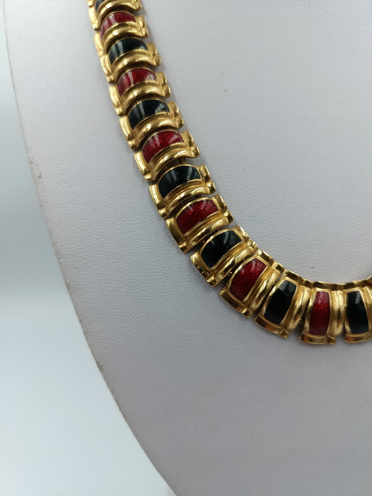 Halskette mit goldfarbenen Gliedern und rot schwarzen Emaille Elementen