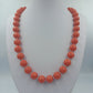 Korallenfarbene Perlenkette mit Goldverschluss 58 cm