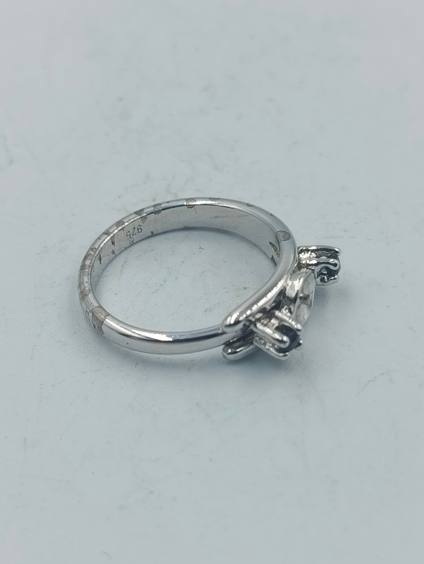 Eleganter Silberring mit dunklen Seitensteinen und mittiger Fassung