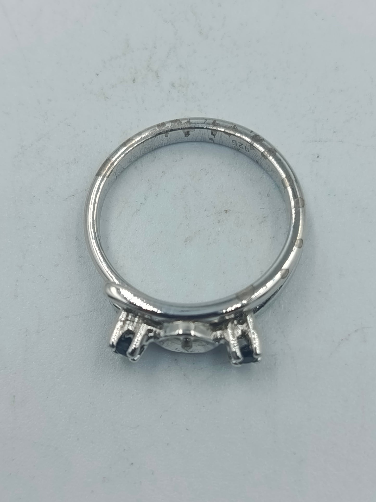 Eleganter Silberring mit dunklen Seitensteinen und mittiger Fassung