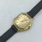 Vintage Armbanduhr mit achteckigem goldfarbenem Gehäuse und schwarzem Band