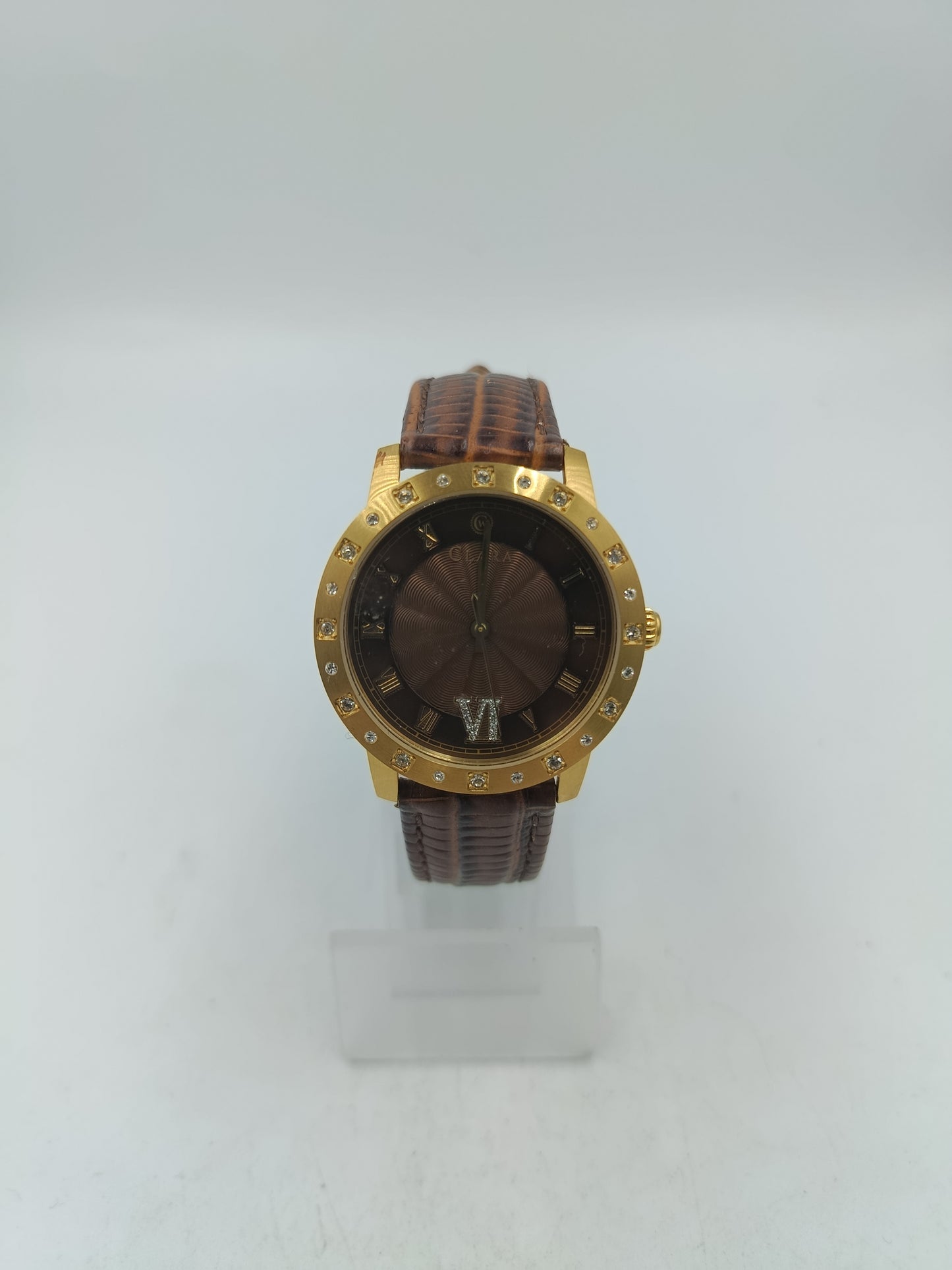 Elegante Armbanduhr mit braunem Lederband goldfarbenem Gehäuse und funkelnden Ziersteinen