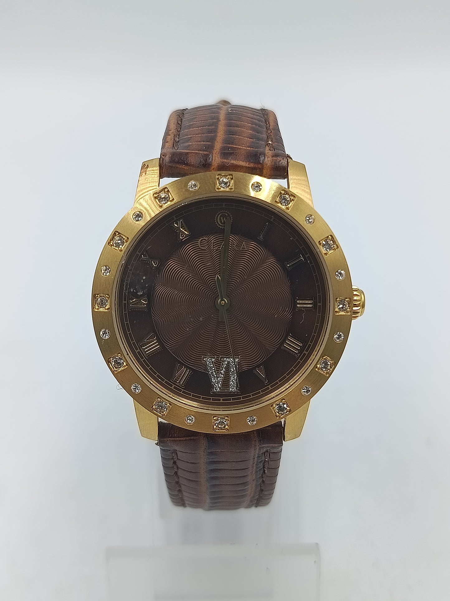 Elegante Armbanduhr mit braunem Lederband goldfarbenem Gehäuse und funkelnden Ziersteinen