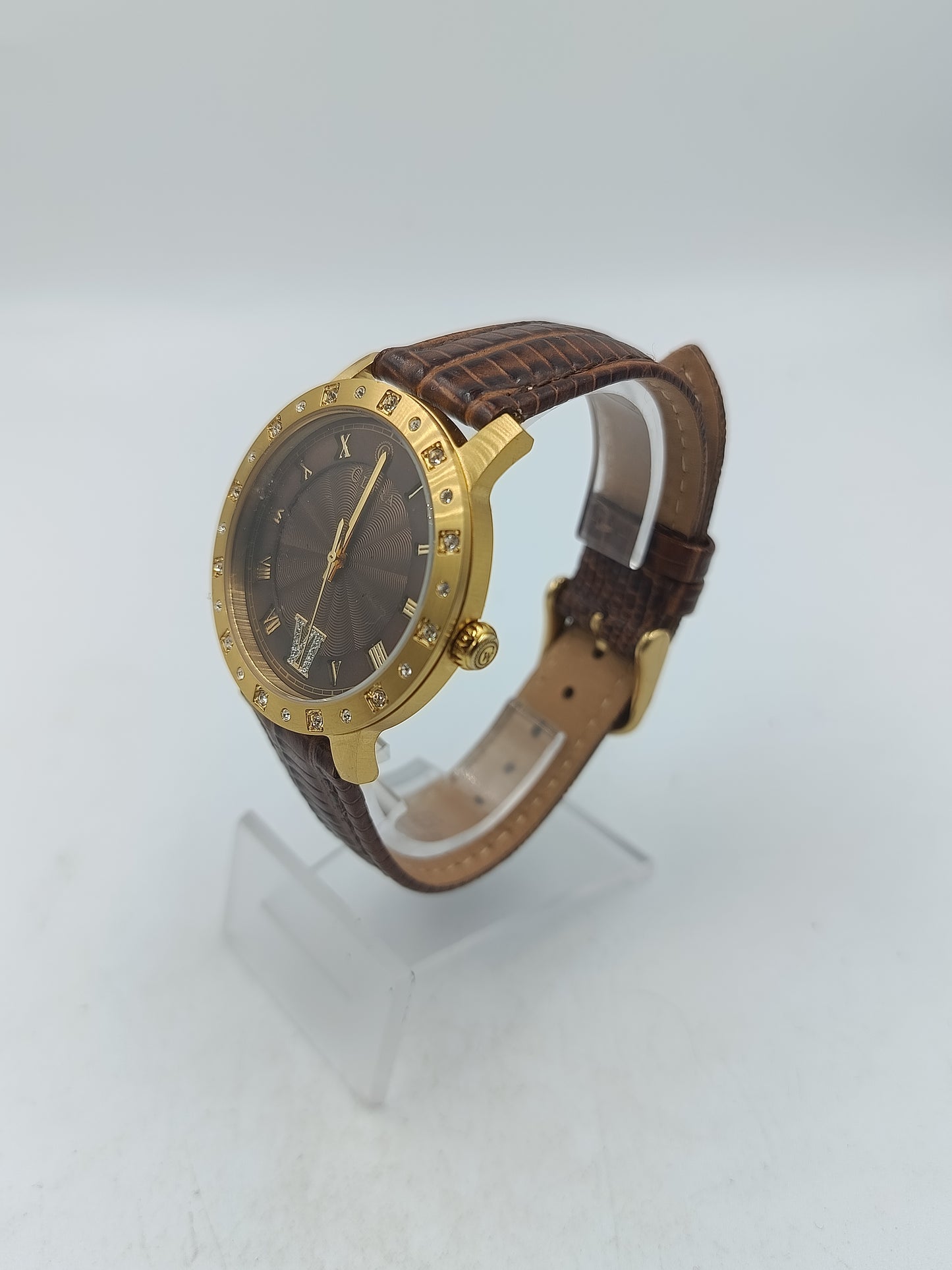 Elegante Armbanduhr mit braunem Lederband goldfarbenem Gehäuse und funkelnden Ziersteinen