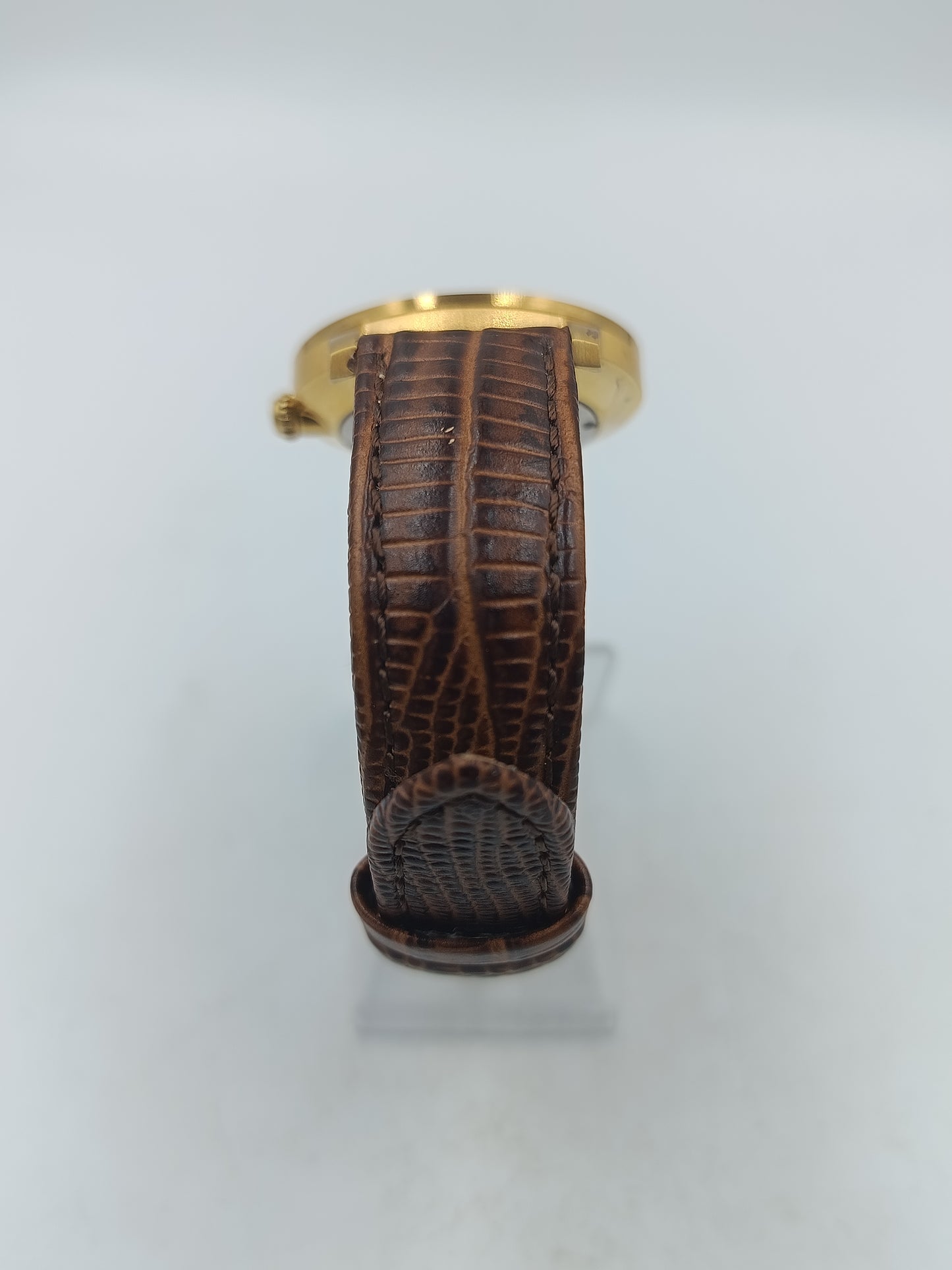 Elegante Armbanduhr mit braunem Lederband goldfarbenem Gehäuse und funkelnden Ziersteinen