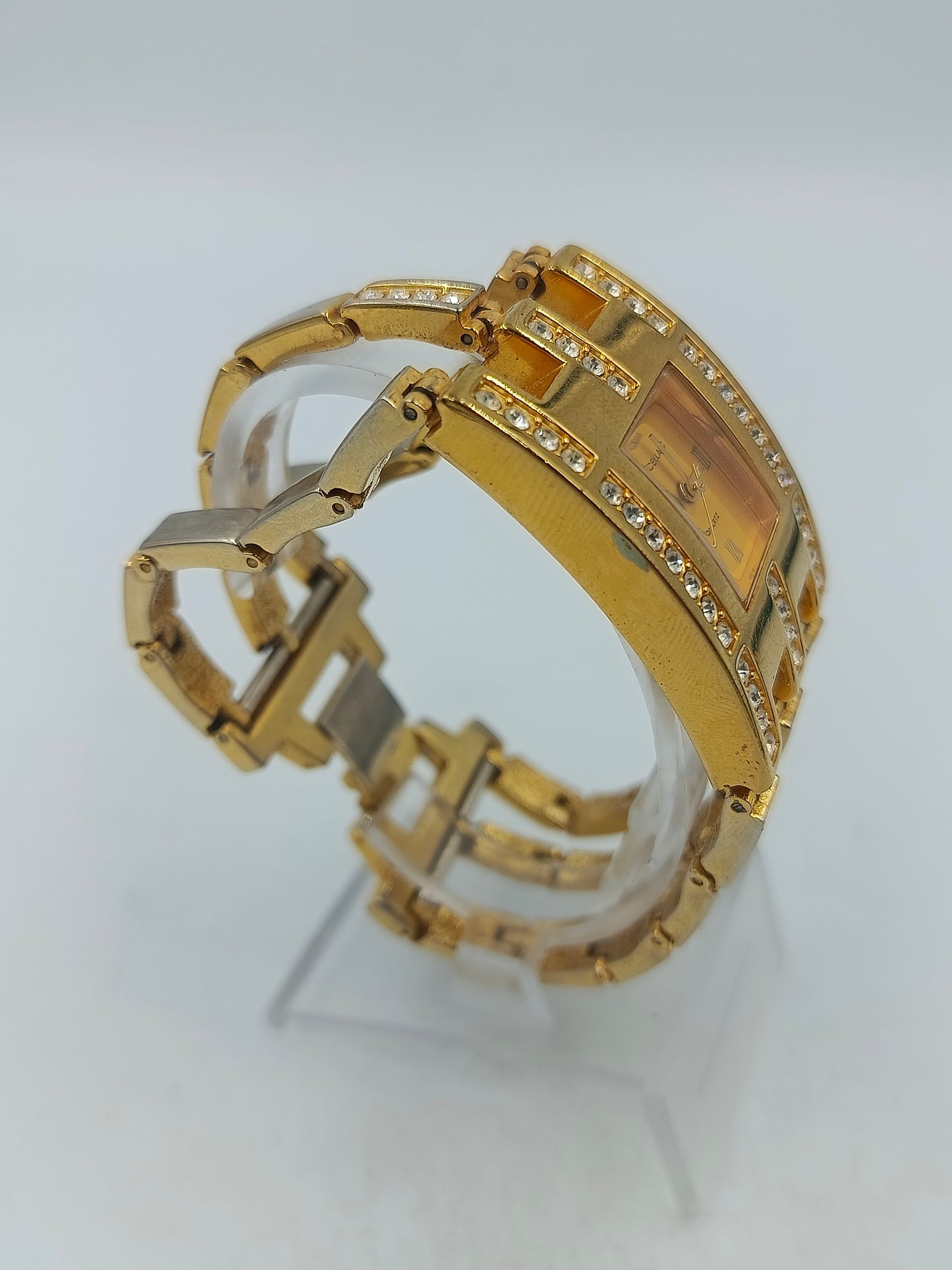 Elegante Armbanduhr mit goldfarbenem Gehäuse und funkelnden Steinen