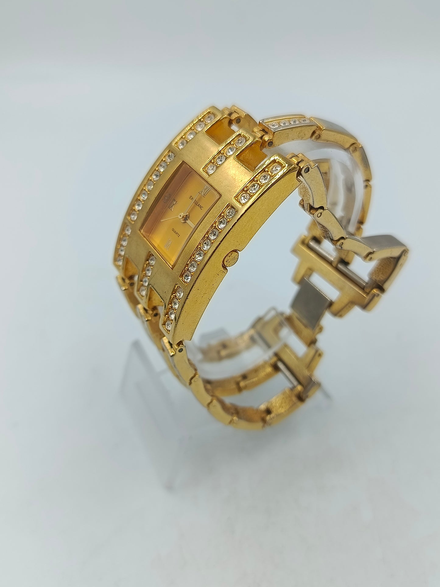 Elegante Armbanduhr mit goldfarbenem Gehäuse und funkelnden Steinen