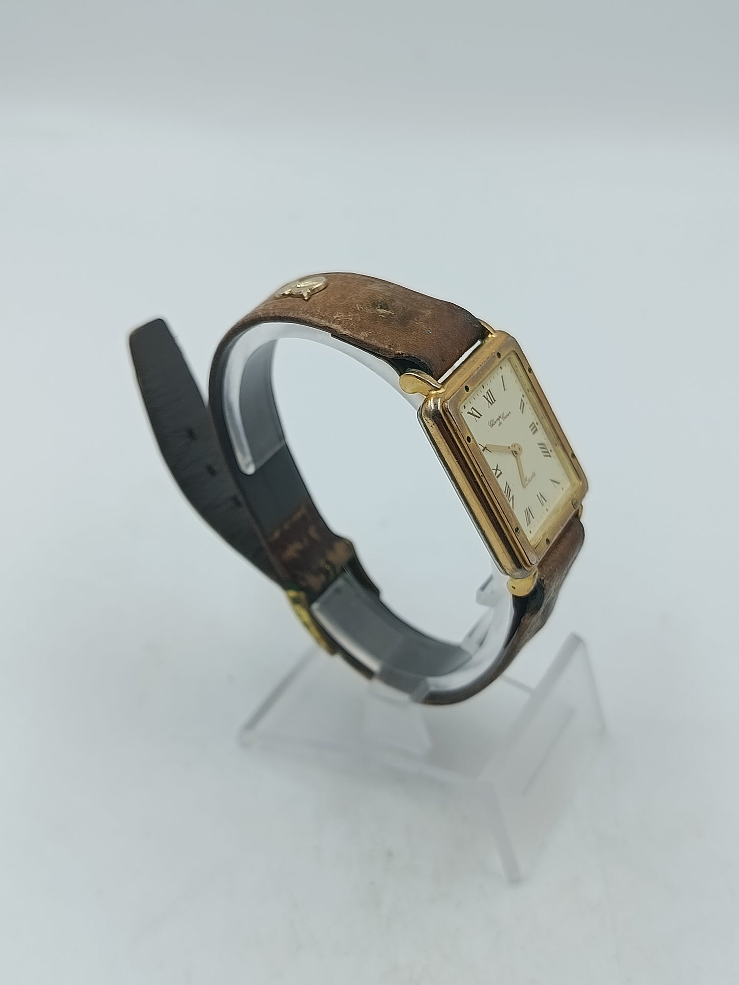 Rechteckige Armbanduhr mit braunem Lederband und römischen Ziffern im klassischen Stil