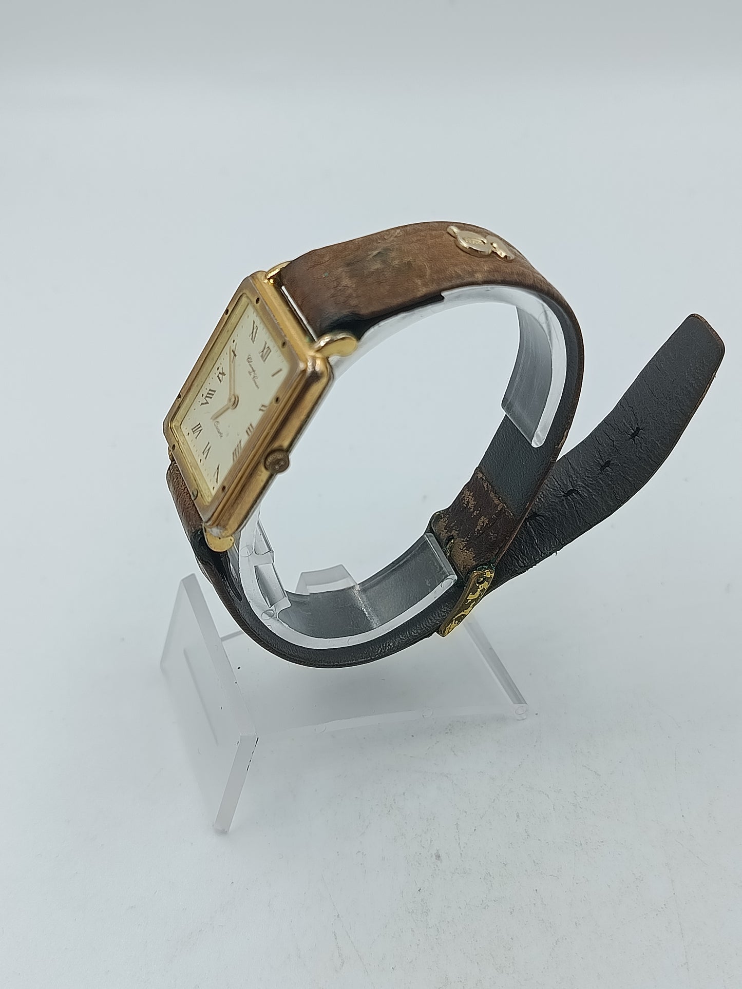 Rechteckige Armbanduhr mit braunem Lederband und römischen Ziffern im klassischen Stil