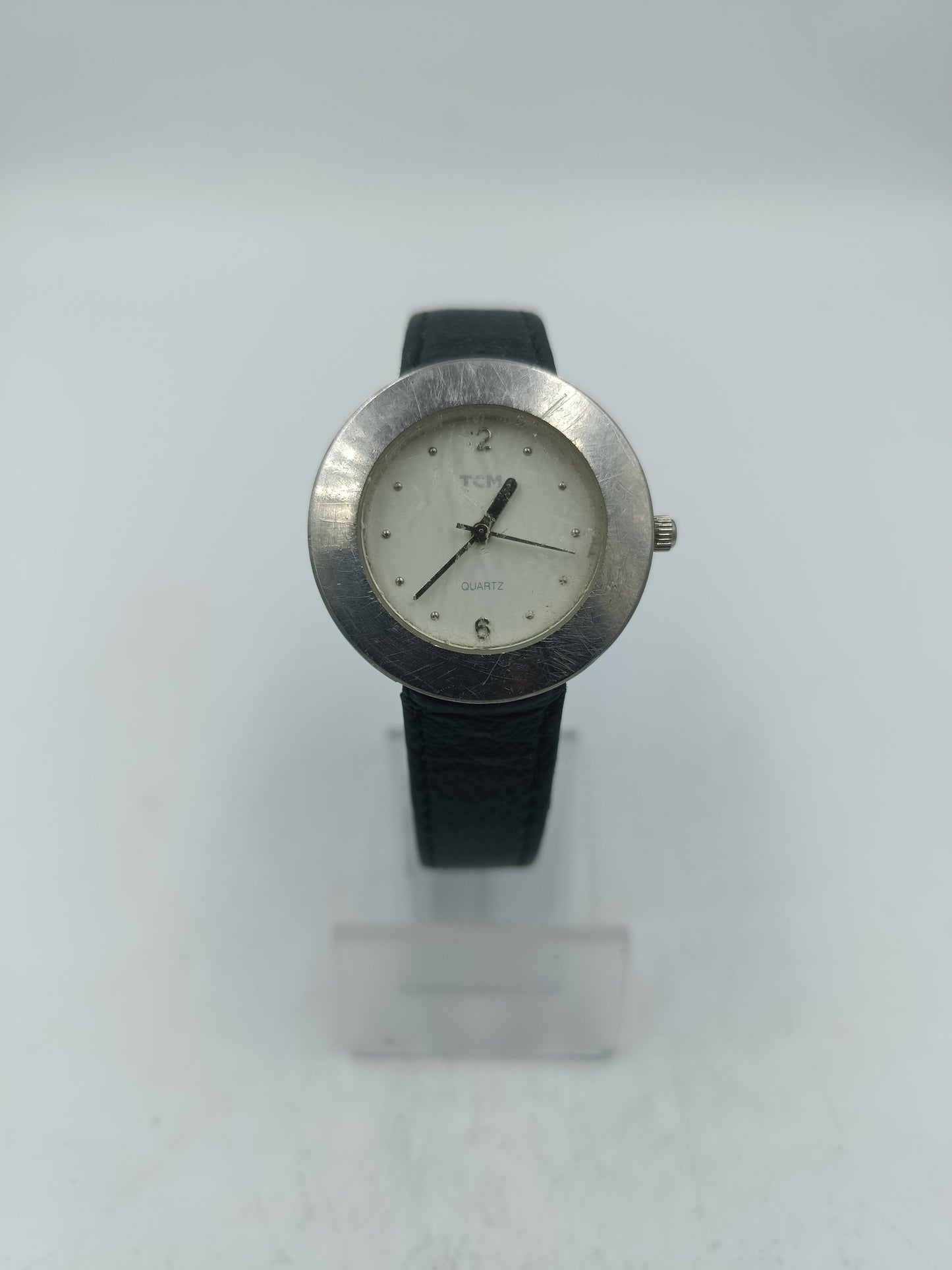 Runde Armbanduhr mit schwarzem Lederarmband und schlichtem Zifferblatt in Silberoptik