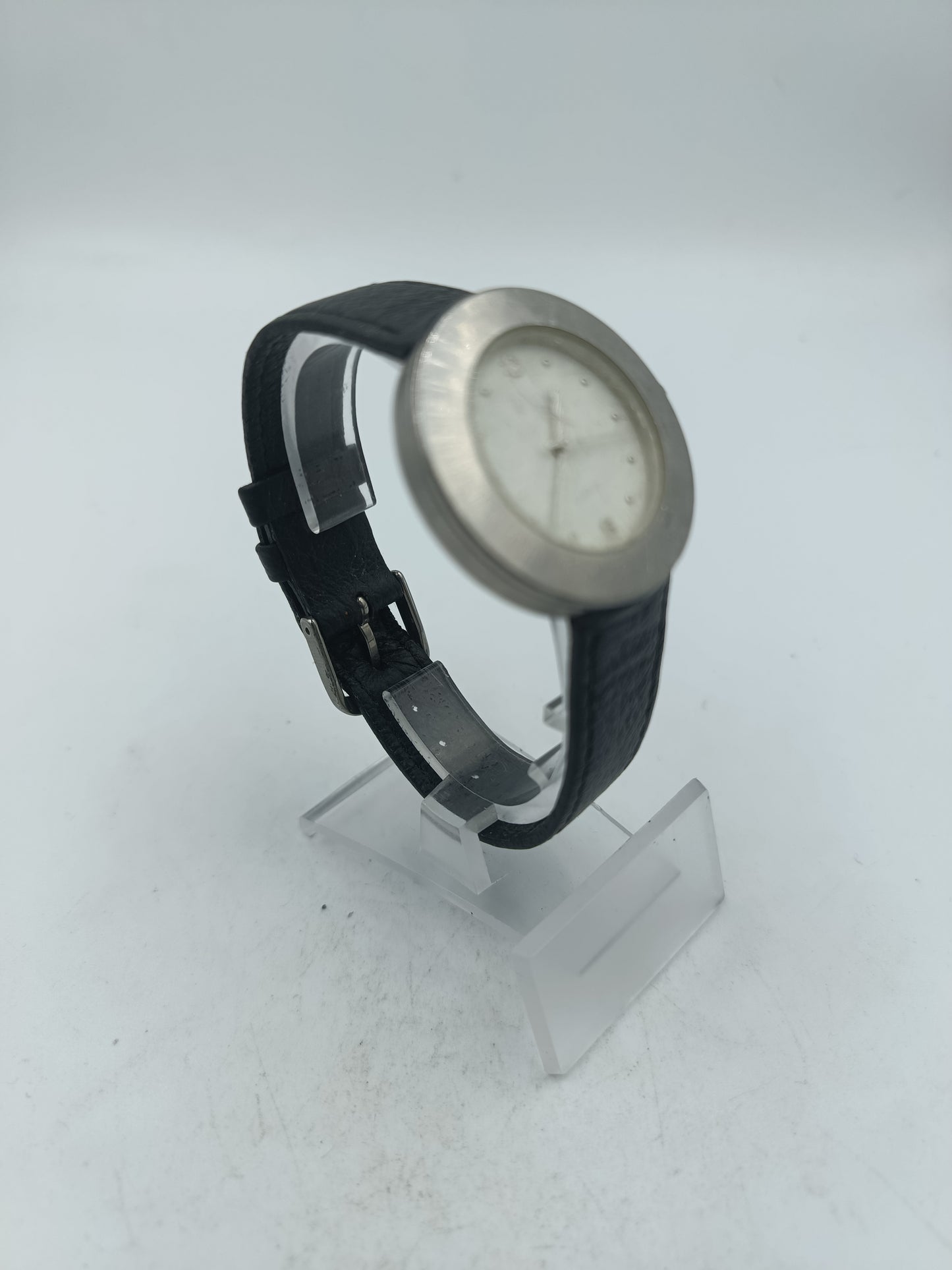 Runde Armbanduhr mit schwarzem Lederarmband und schlichtem Zifferblatt in Silberoptik