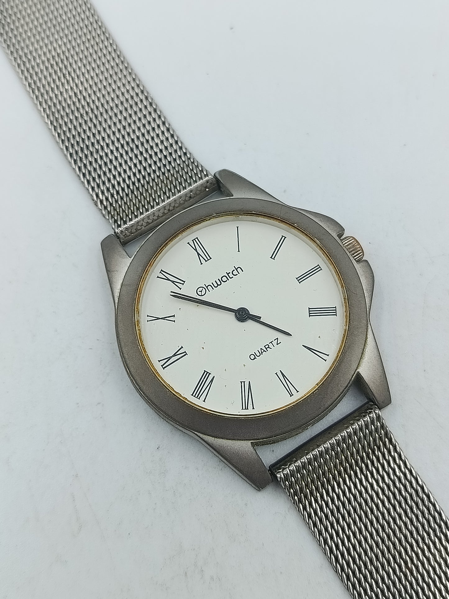 Silberfarbene Armbanduhr mit römischen Ziffern und fein gearbeitetem Milanaiseband