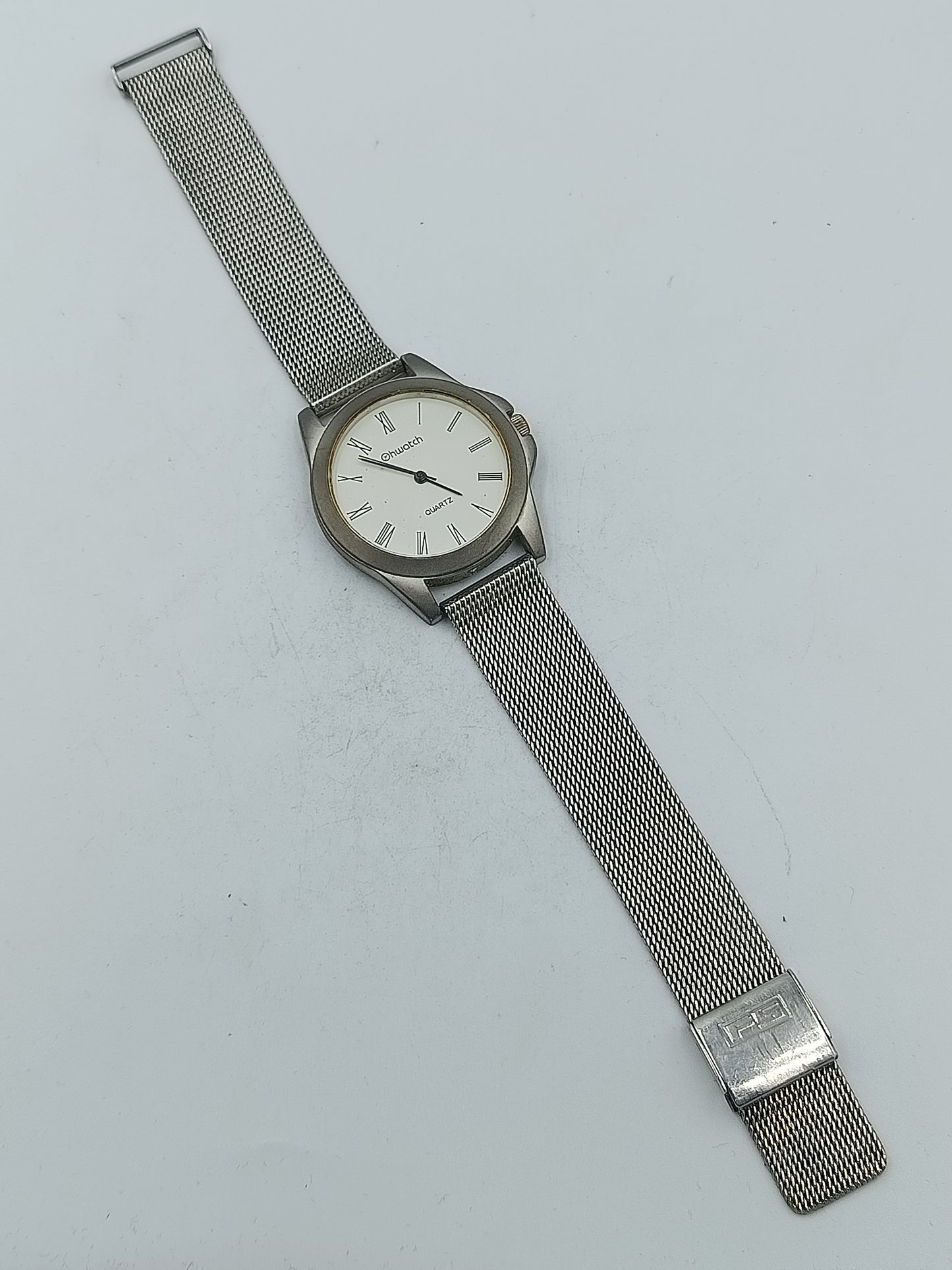 Silberfarbene Armbanduhr mit römischen Ziffern und fein gearbeitetem Milanaiseband