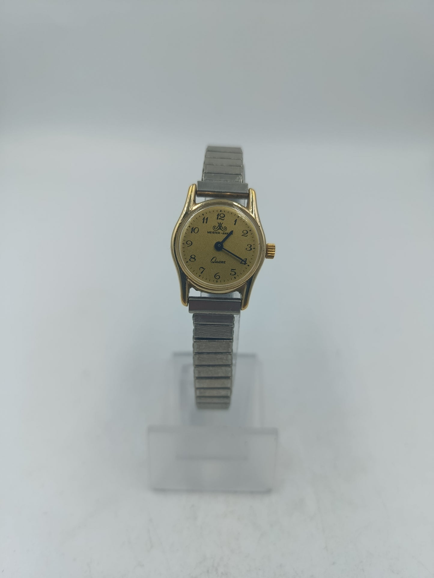 Goldfarbene Armbanduhr mit elastischem Metallband und klassischem Zifferblatt im Vintage Stil