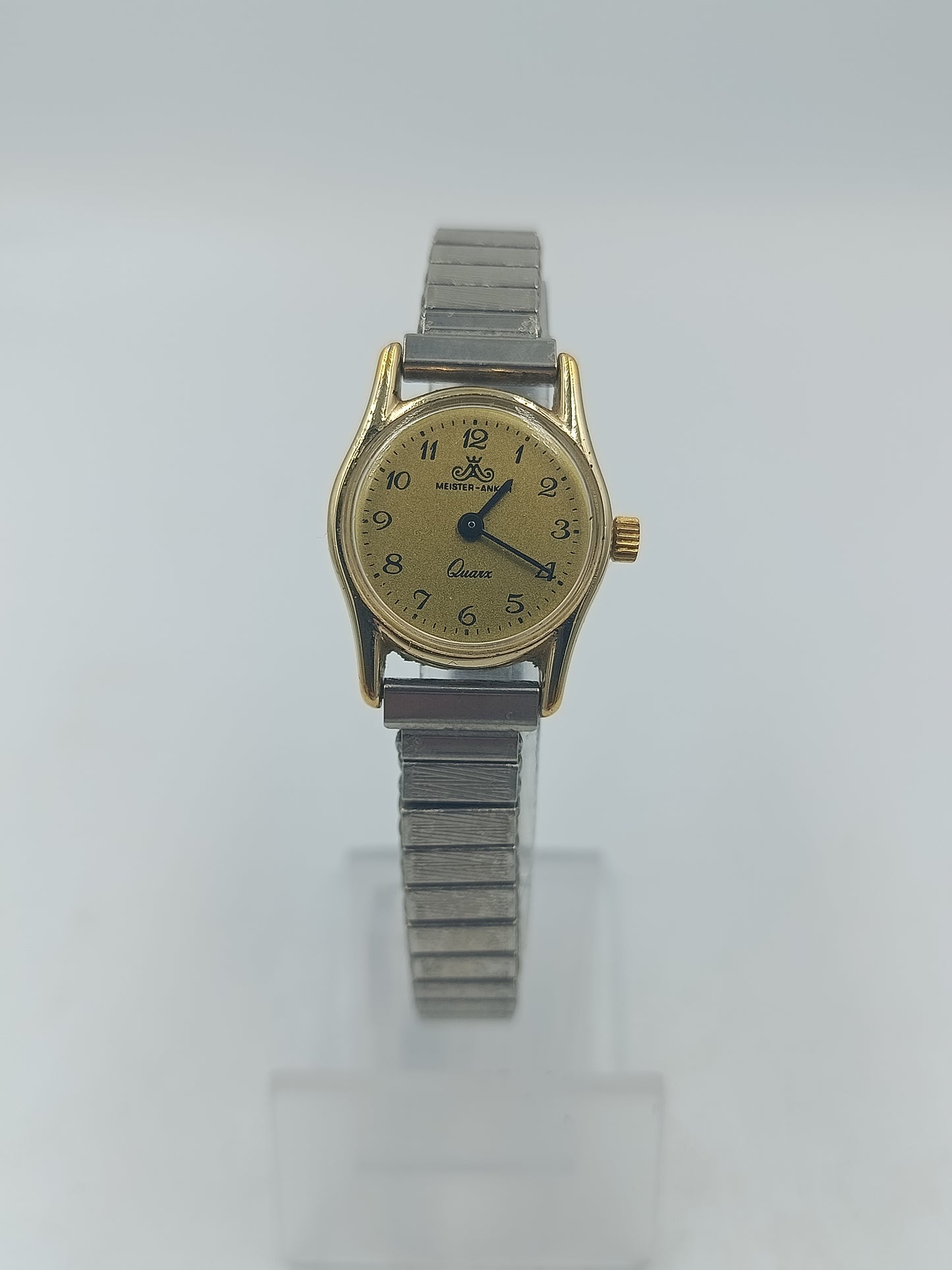 Goldfarbene Armbanduhr mit elastischem Metallband und klassischem Zifferblatt im Vintage Stil