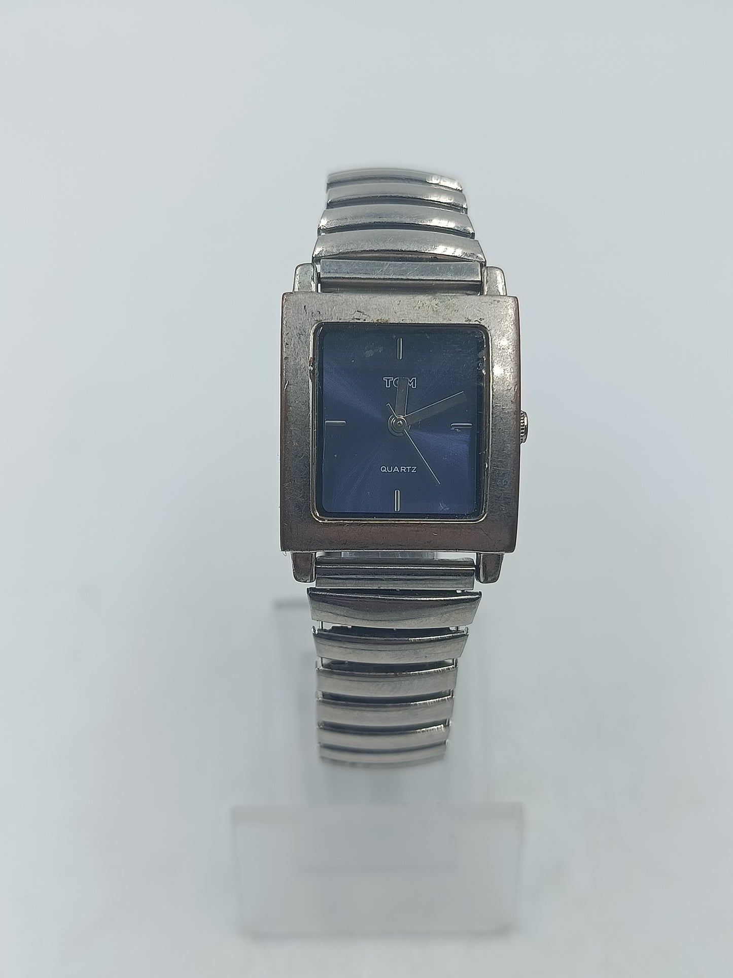 Rechteckige Armbanduhr mit blauem Zifferblatt und elastischem Metallarmband im klassischen Design