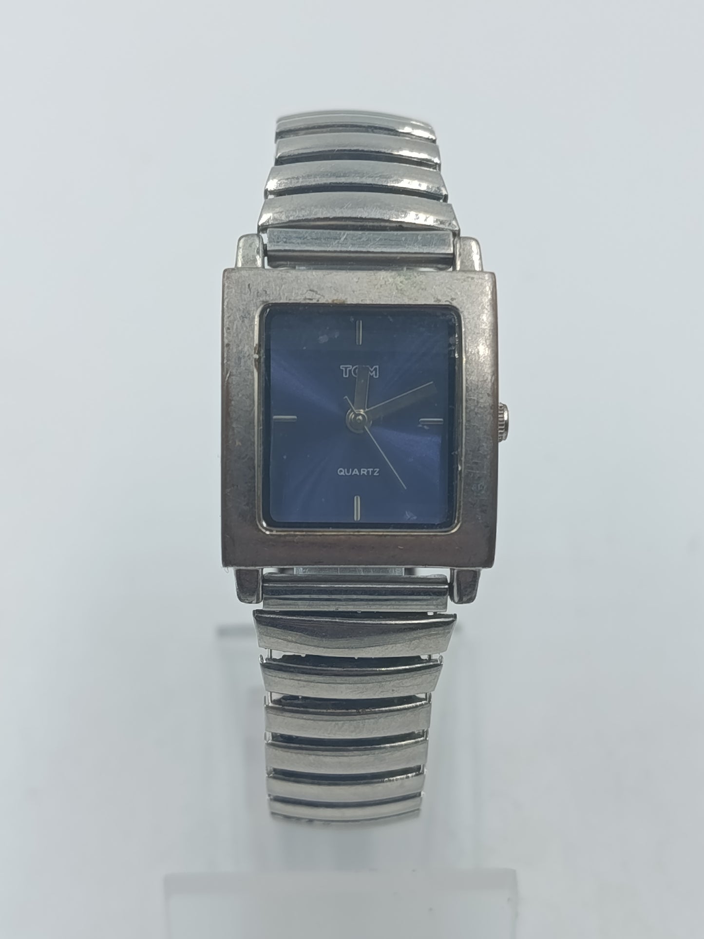 Rechteckige Armbanduhr mit blauem Zifferblatt und elastischem Metallarmband im klassischen Design