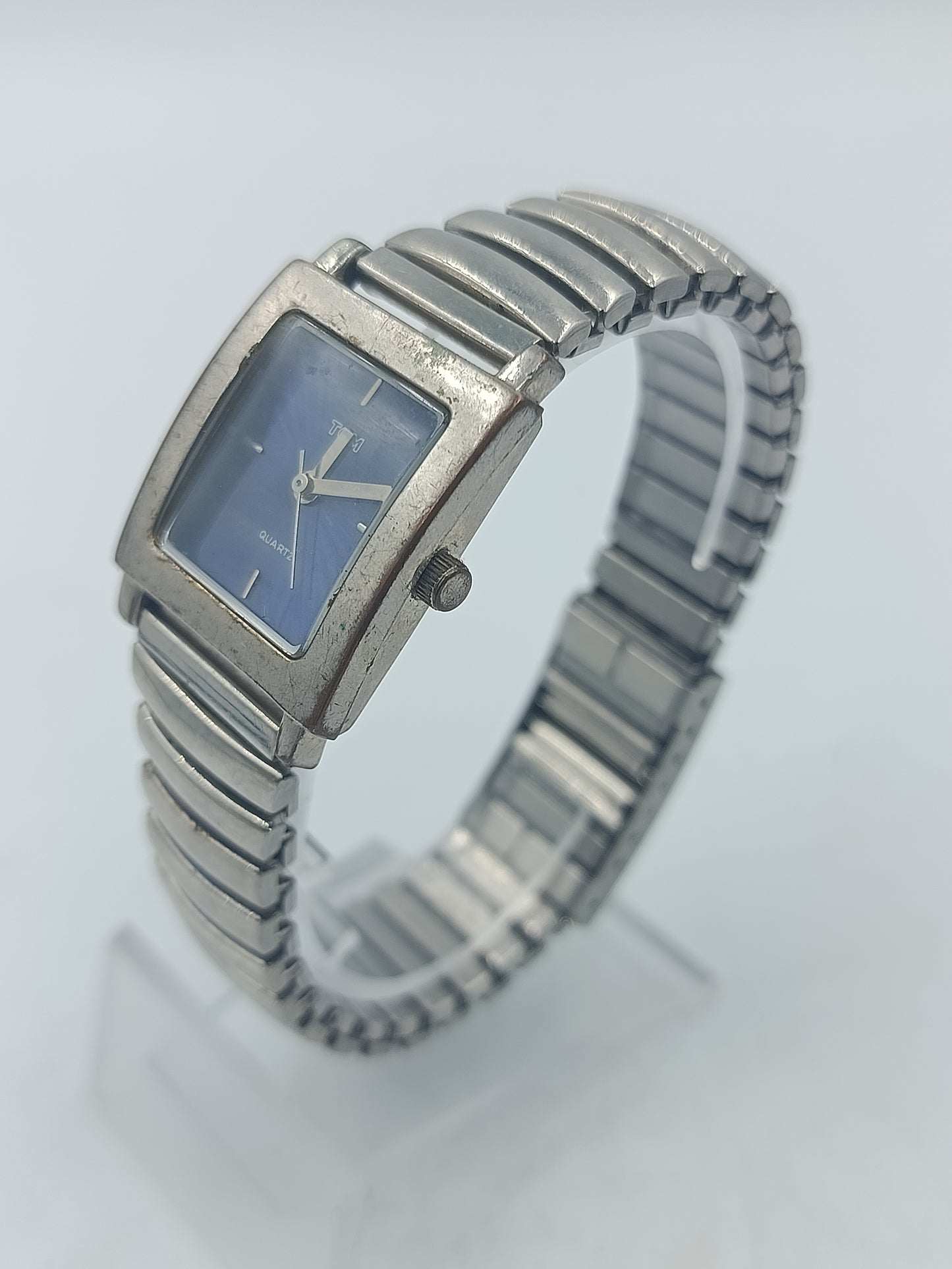 Rechteckige Armbanduhr mit blauem Zifferblatt und elastischem Metallarmband im klassischen Design