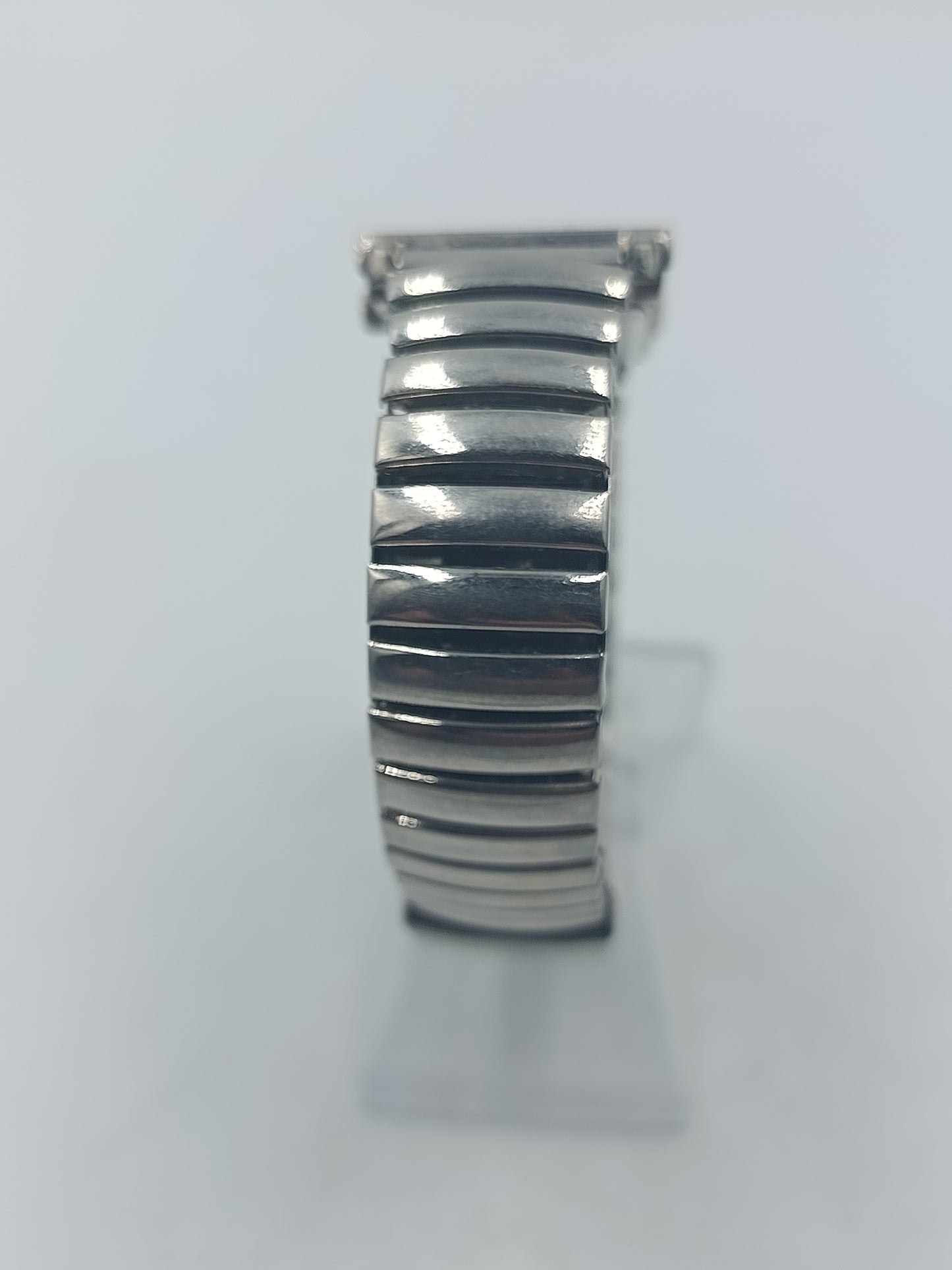 Rechteckige Armbanduhr mit blauem Zifferblatt und elastischem Metallarmband im klassischen Design