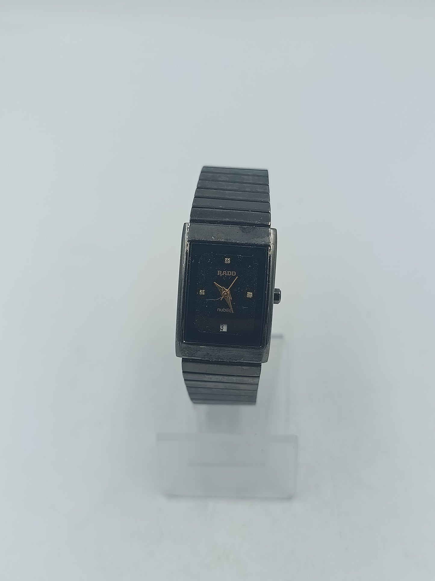 Rechteckige Armbanduhr mit schwarzem Zifferblatt und elastischem Metallarmband im klassischen Design