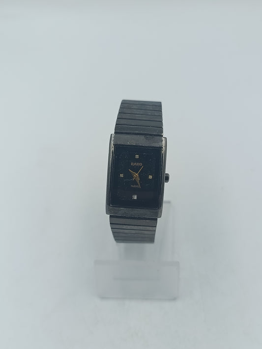 Rechteckige Armbanduhr mit schwarzem Zifferblatt und elastischem Metallarmband im klassischen Design