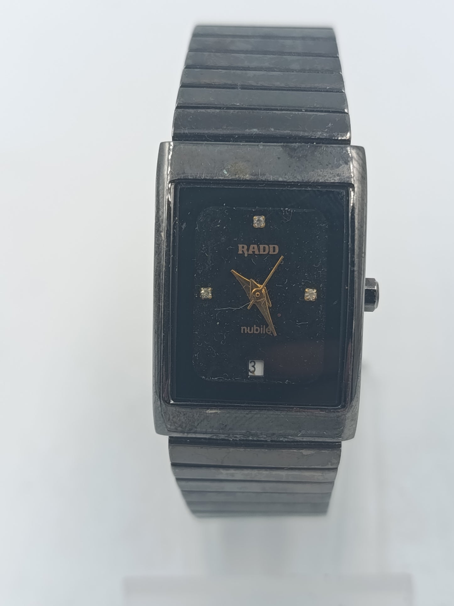 Rechteckige Armbanduhr mit schwarzem Zifferblatt und elastischem Metallarmband im klassischen Design