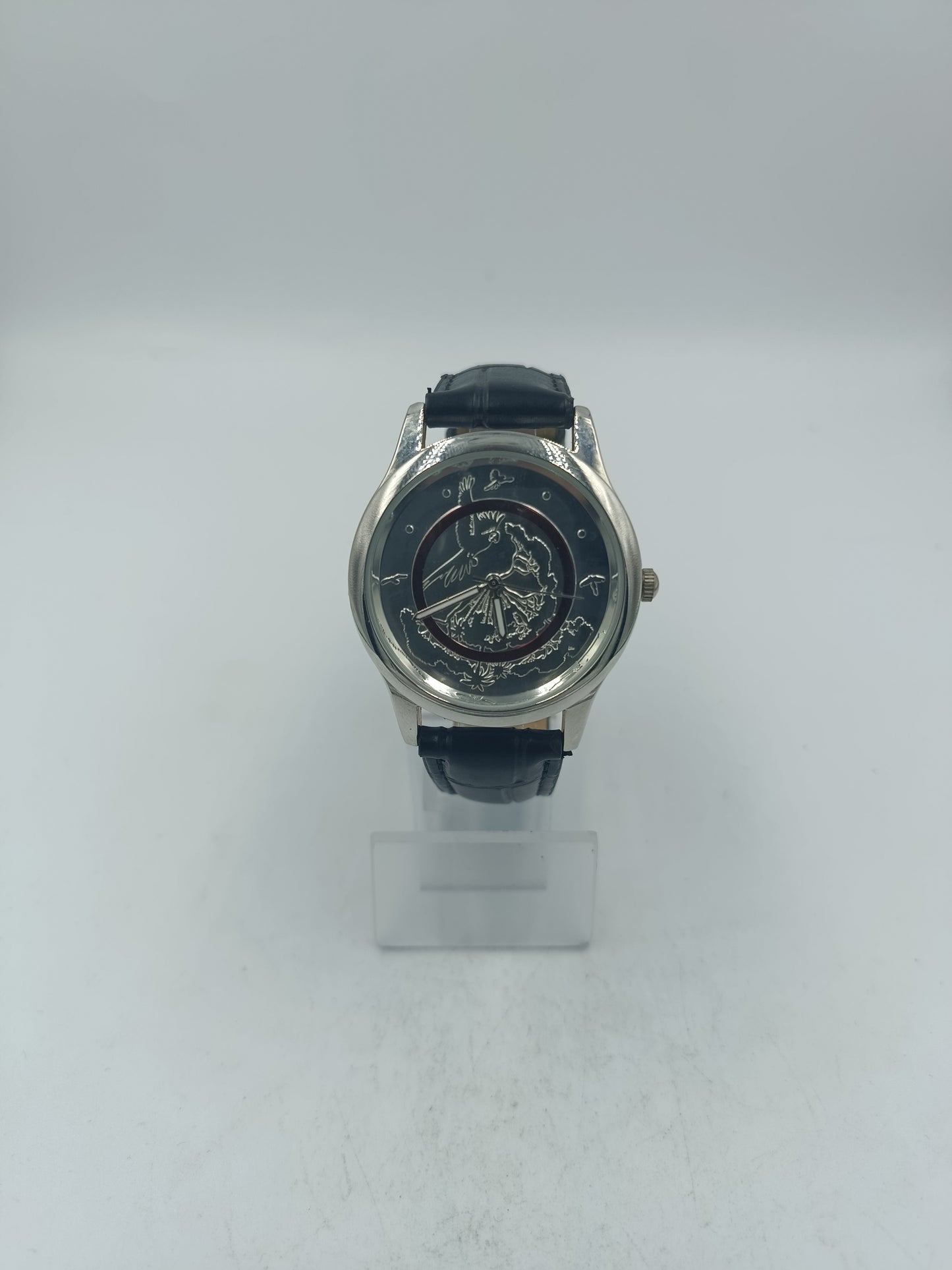 Runde Armbanduhr mit schwarzem Lederband und kunstvollem Motiv Elegant