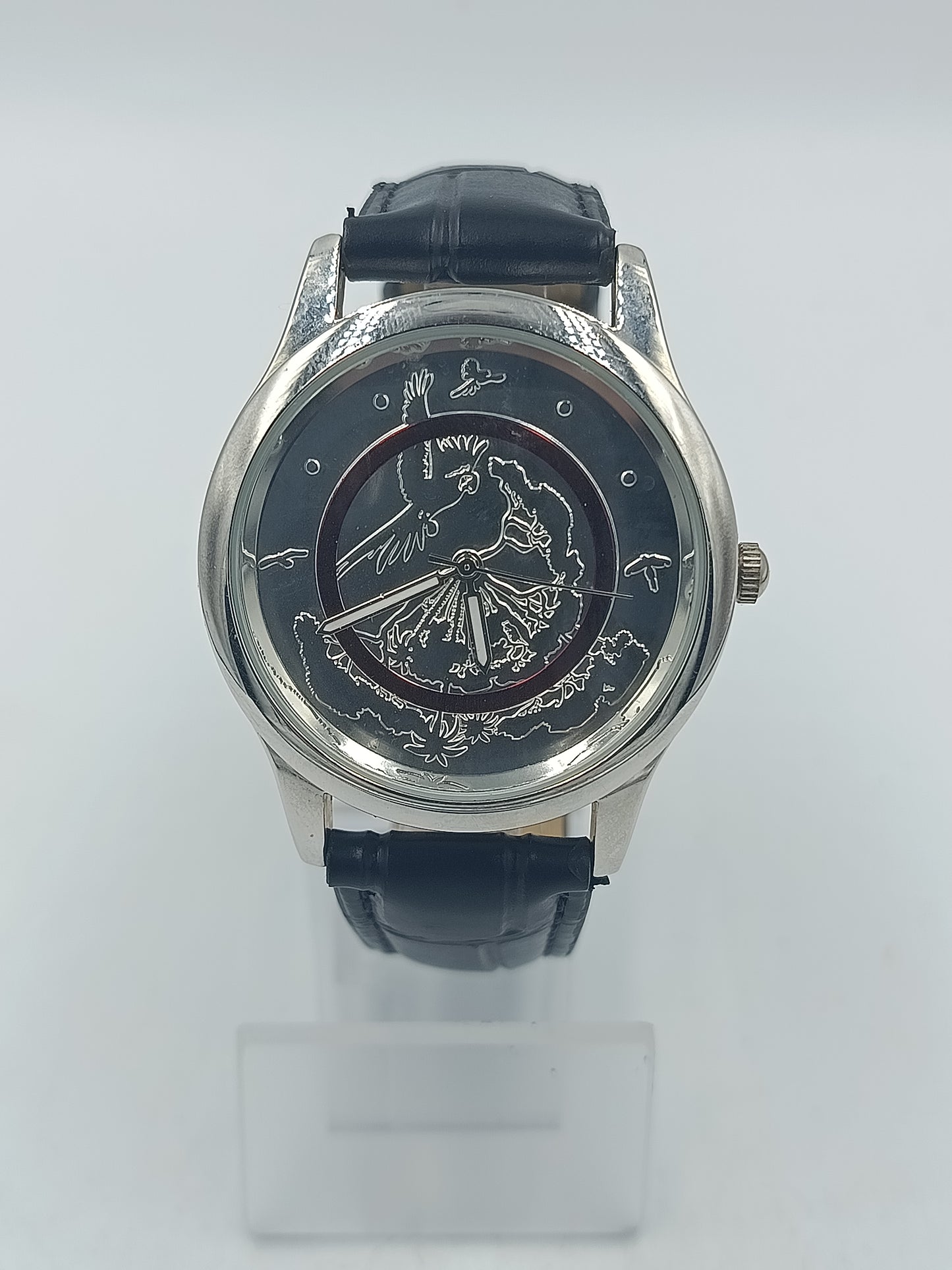 Runde Armbanduhr mit schwarzem Lederband und kunstvollem Motiv Elegant