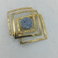 Geometrische Schmuckbrosche goldfarben mit Naturstein und modernem Quadrat Design