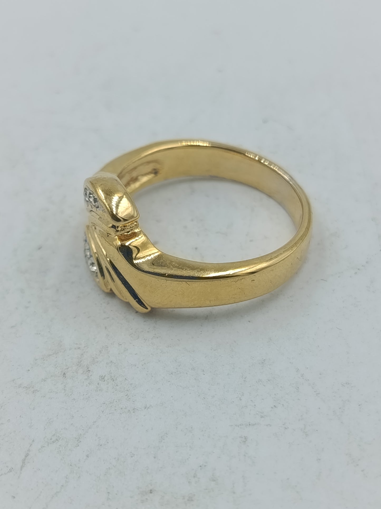 Goldfarbener Ring mit klaren Ziersteinen und elegantem geschwungenem Design