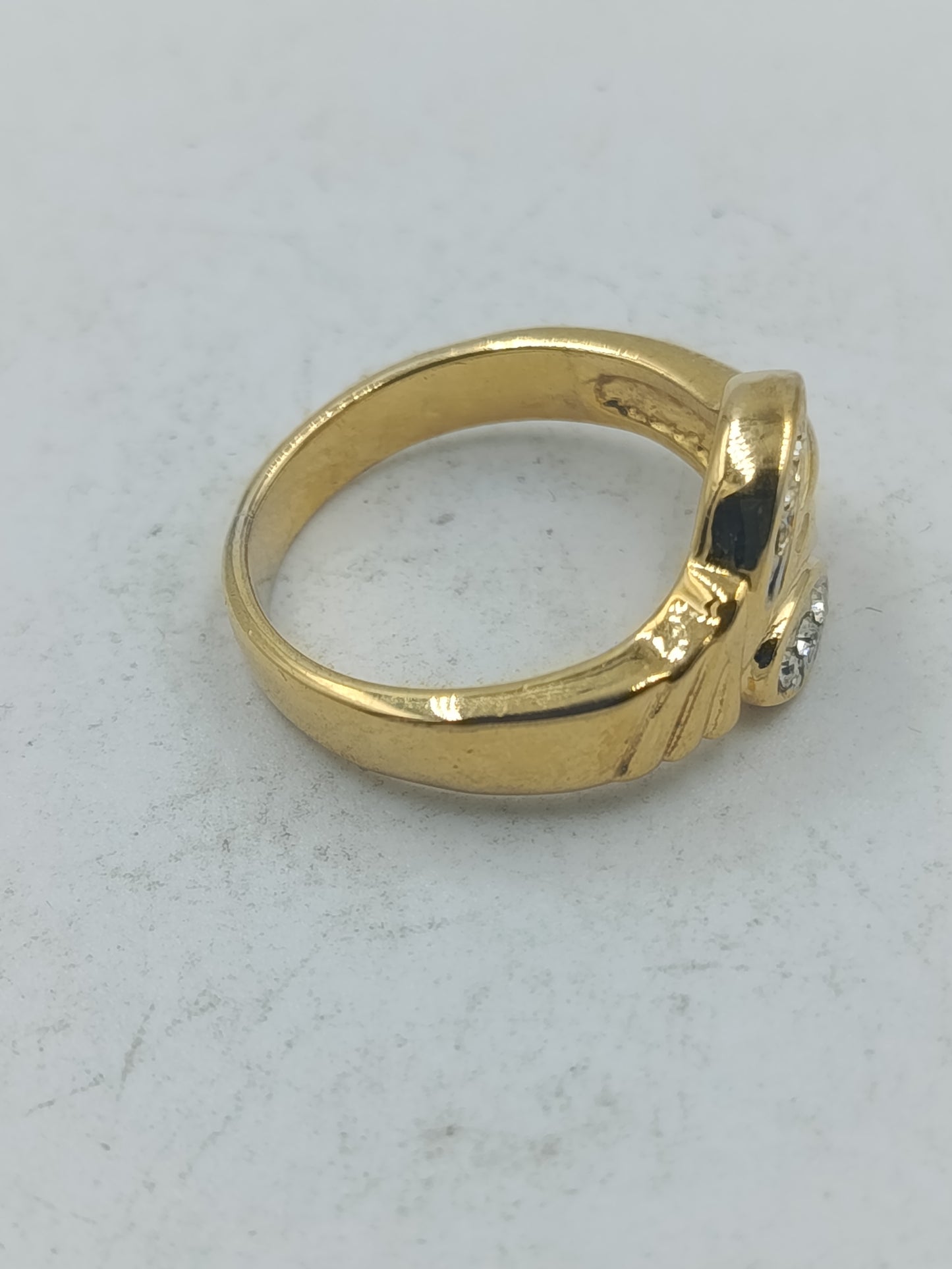Goldfarbener Ring mit klaren Ziersteinen und elegantem geschwungenem Design