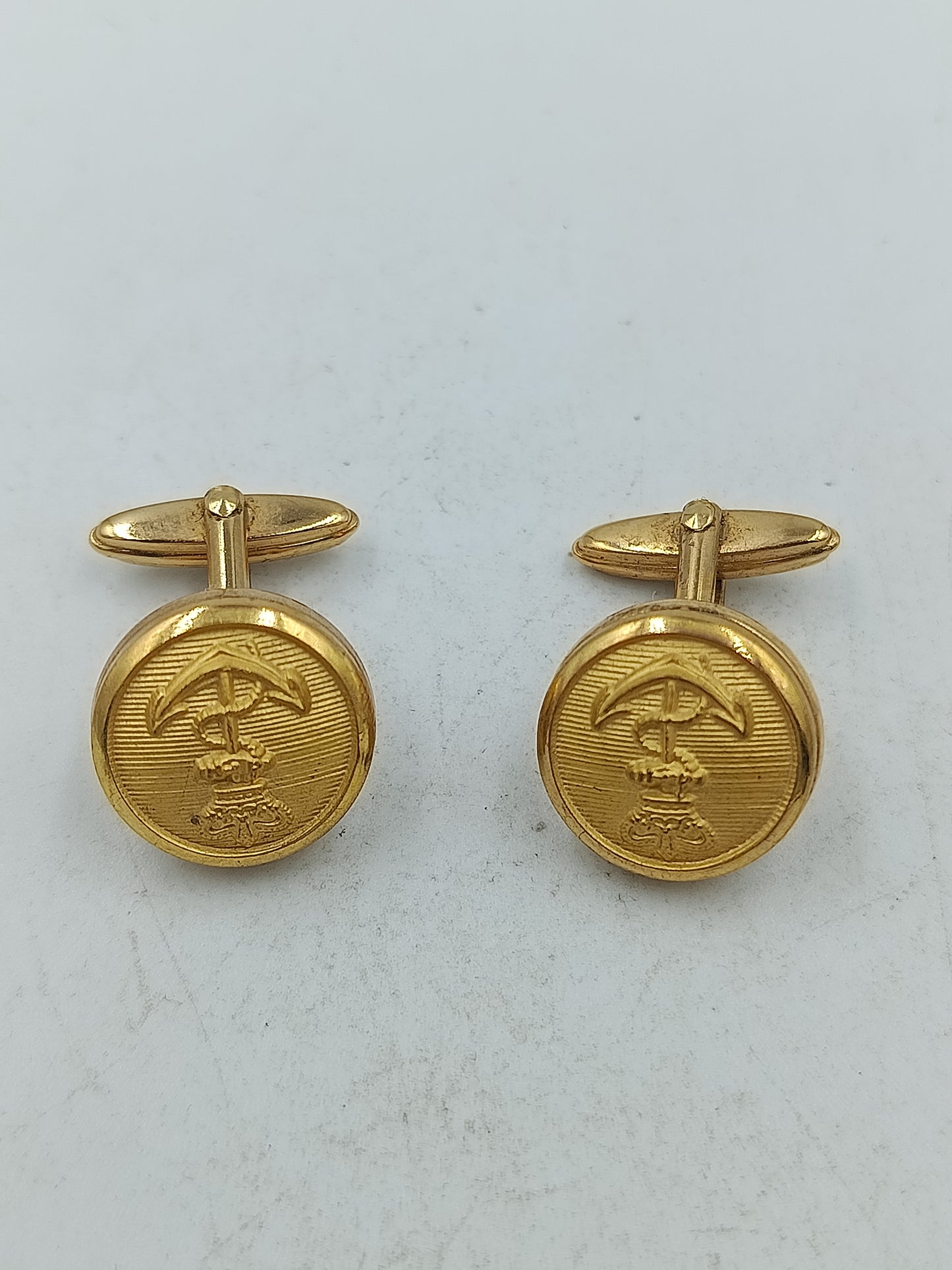 Runde Manschettenknöpfe in Goldoptik mit feiner Prägung und klassischem Motiv