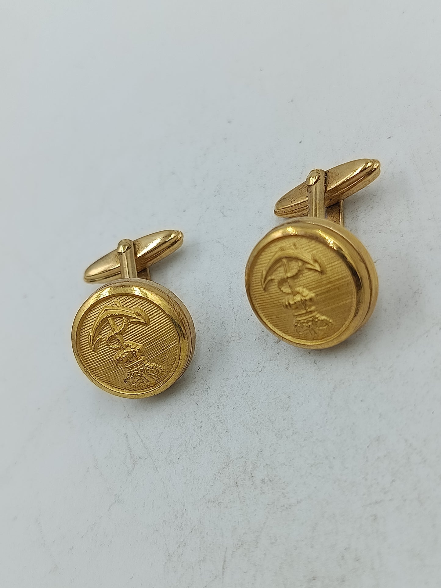 Runde Manschettenknöpfe in Goldoptik mit feiner Prägung und klassischem Motiv