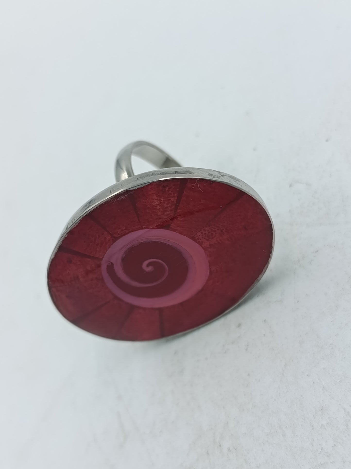 Ovaler Ring mit rotem Spiral Design in moderner silberfarbener Optik