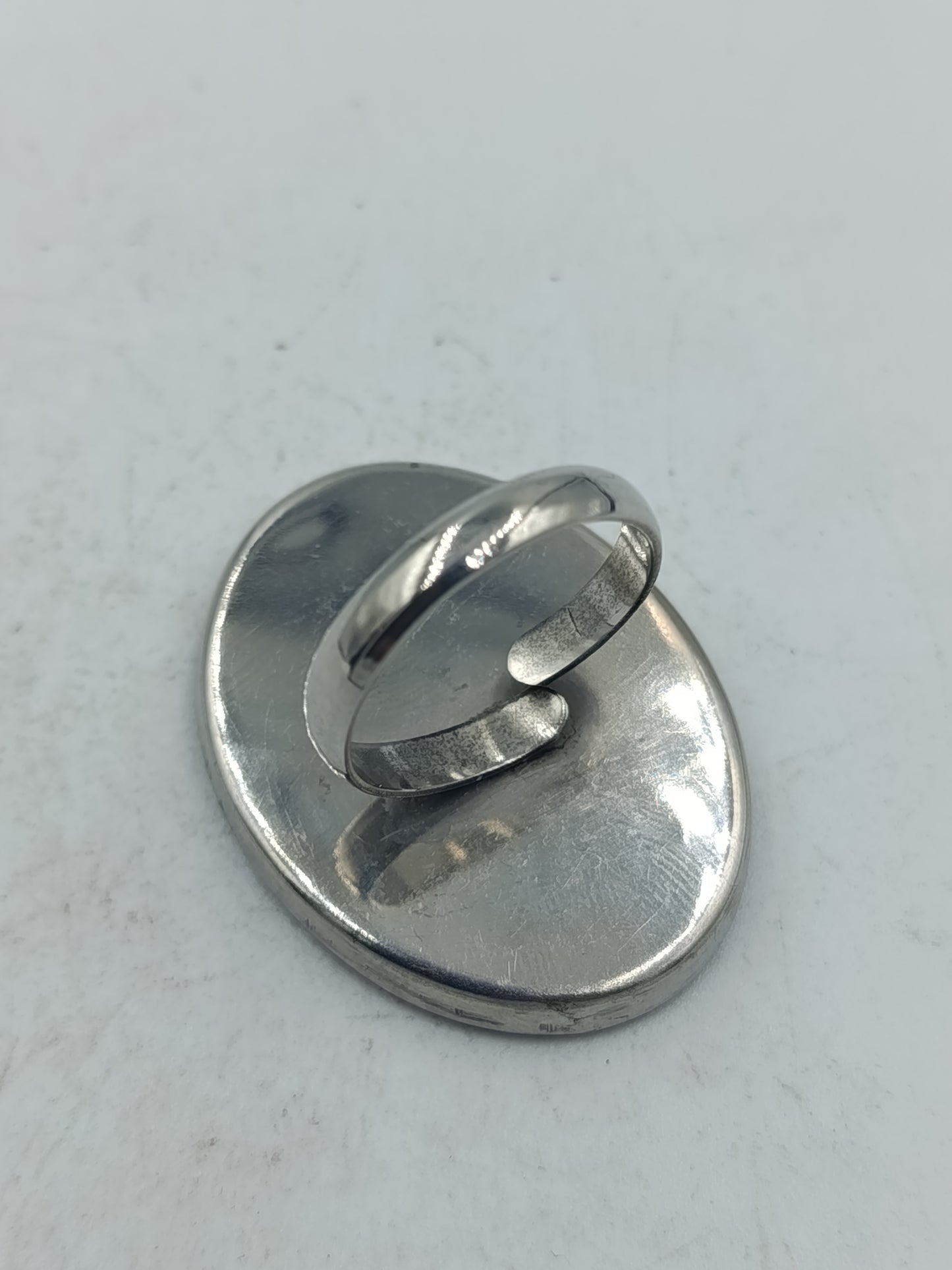 Ovaler Ring mit rotem Spiral Design in moderner silberfarbener Optik