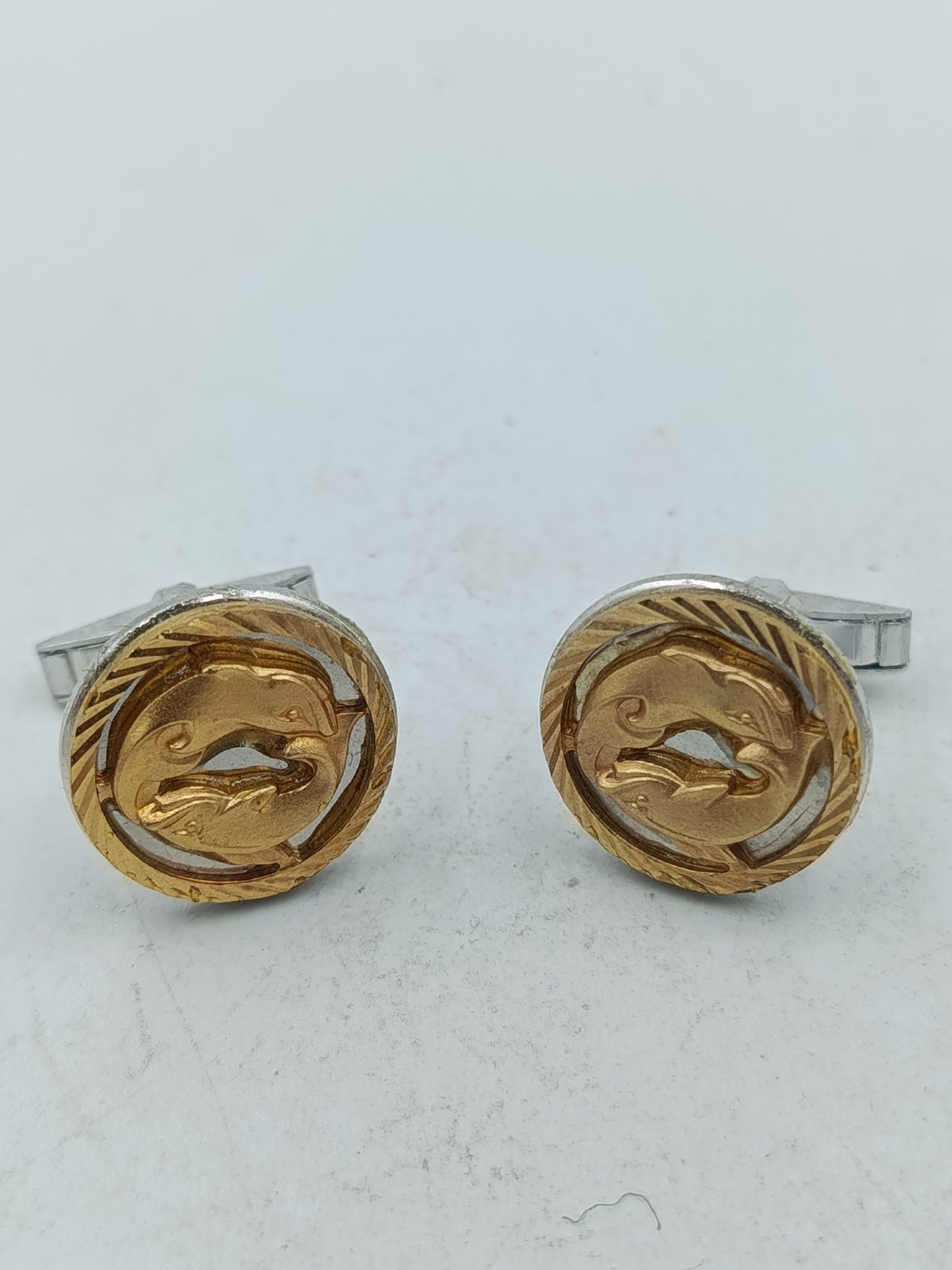 Goldfarbene Manschettenknöpfe mit Delfin Motiv und strukturierter Umrandung