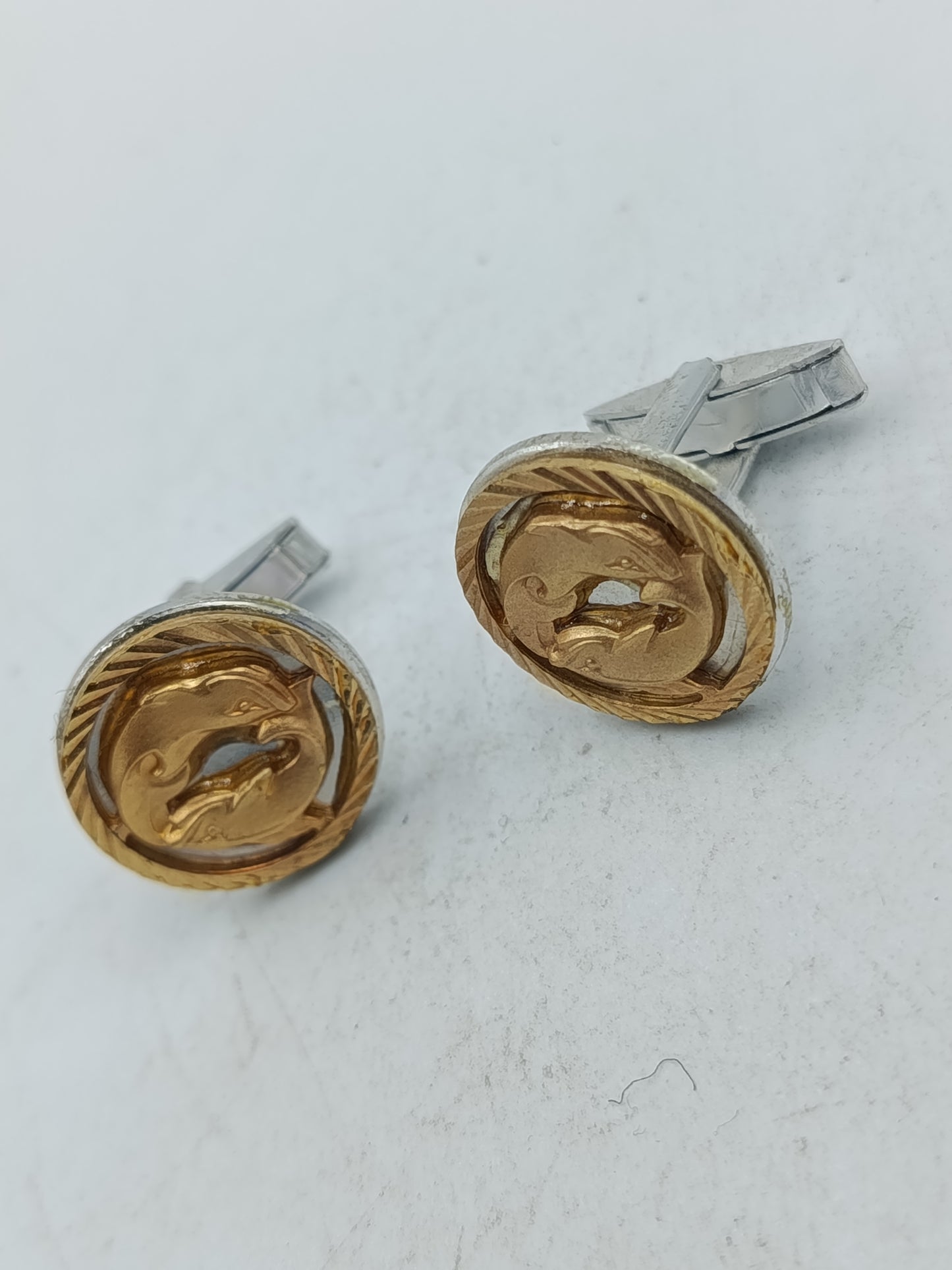 Goldfarbene Manschettenknöpfe mit Delfin Motiv und strukturierter Umrandung